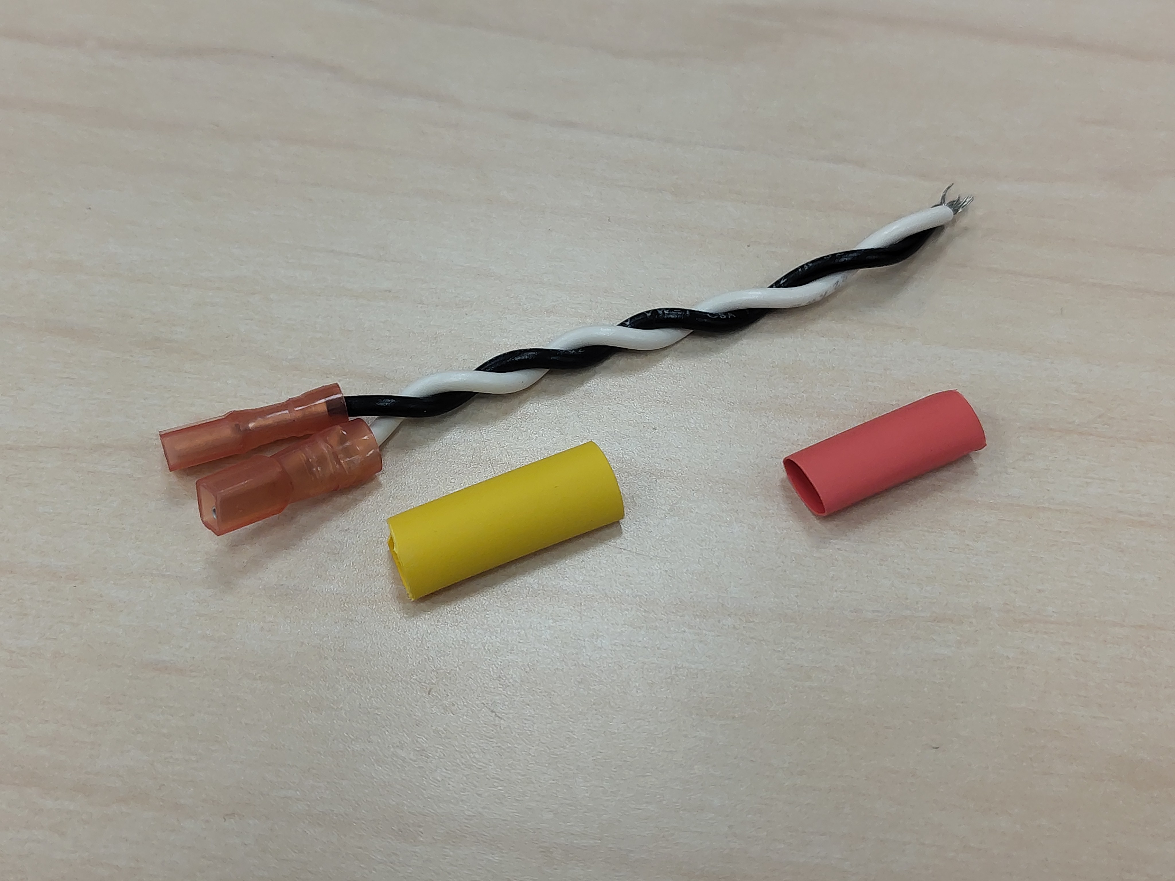 Heat-shrink pieces laid out next to a finished pair