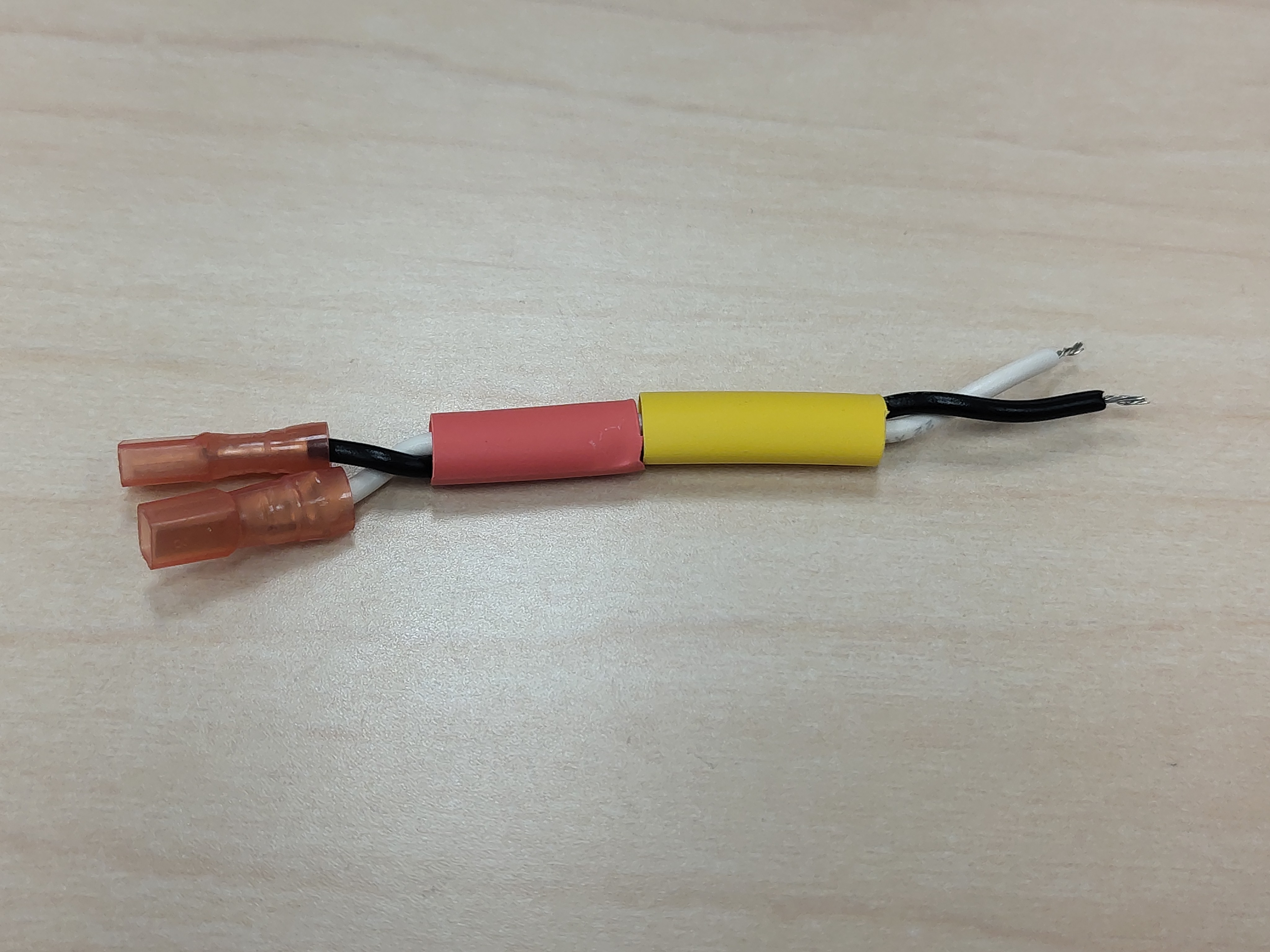 Red and yellow heat-shrink slid onto the pair before shrinking
