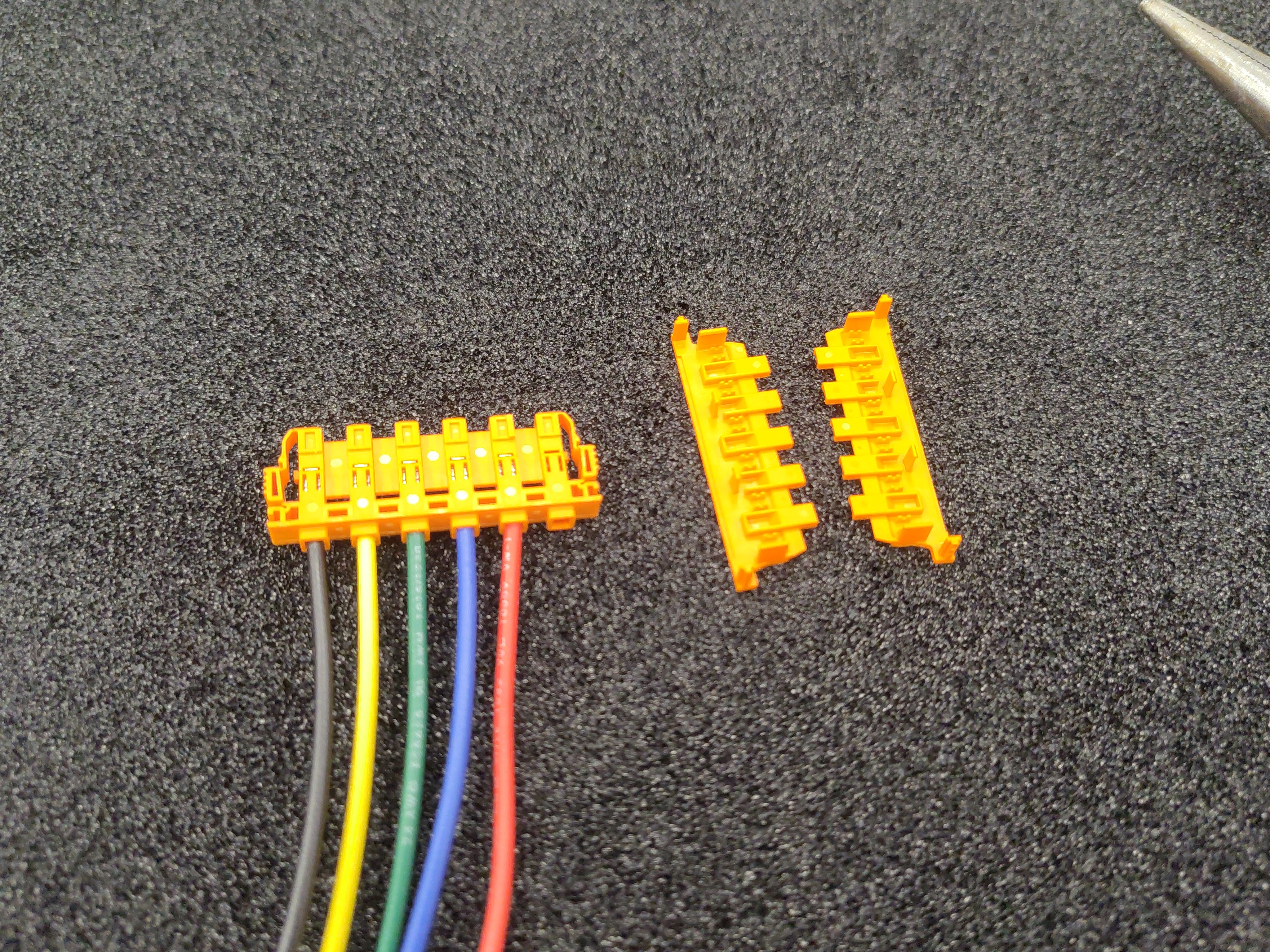 The connector covers laid out next to the populated housing, not yet clipped on