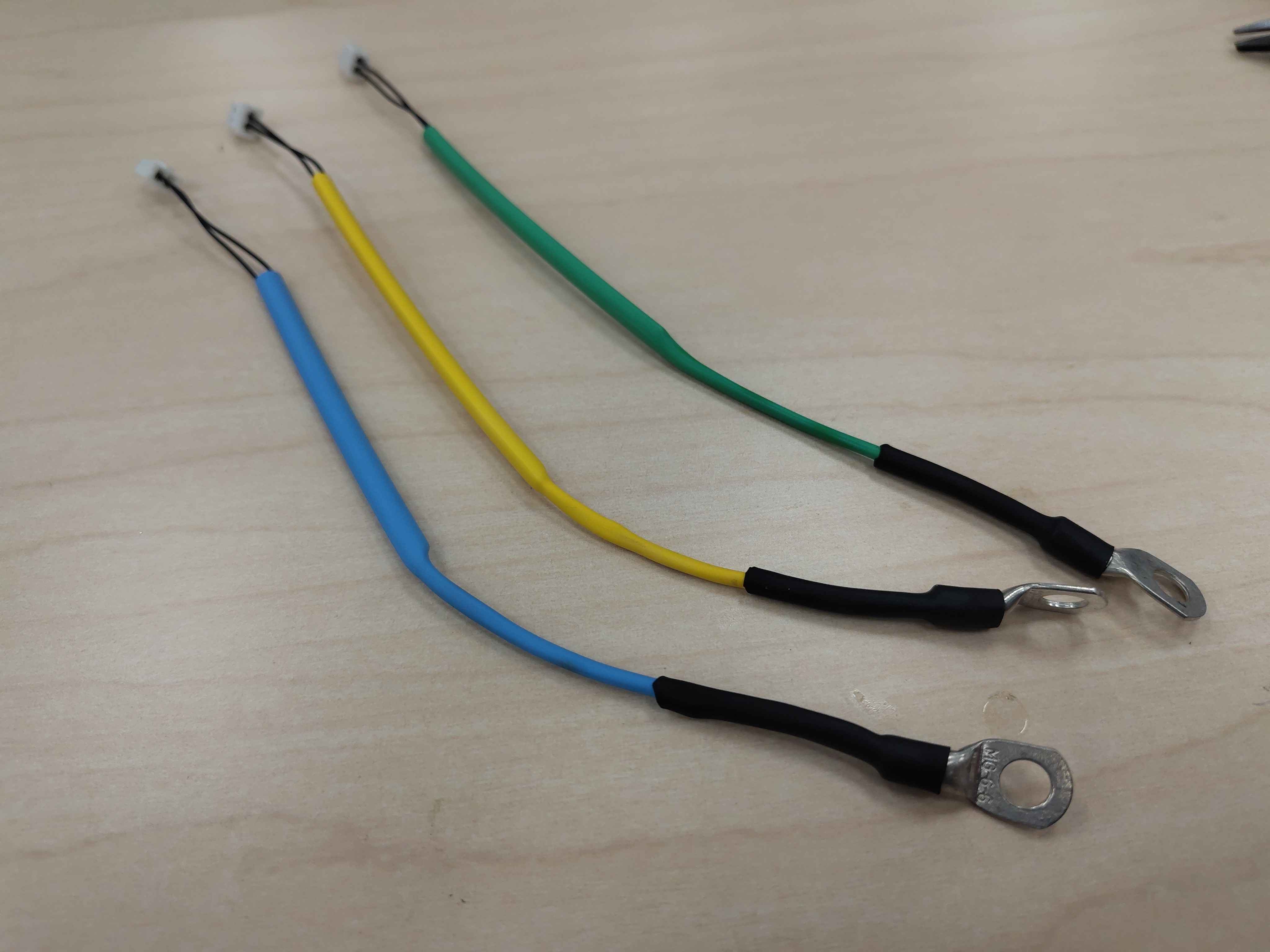 Three finished harnesses with yellow, green, and blue heat-shrink for phases U, V, and W