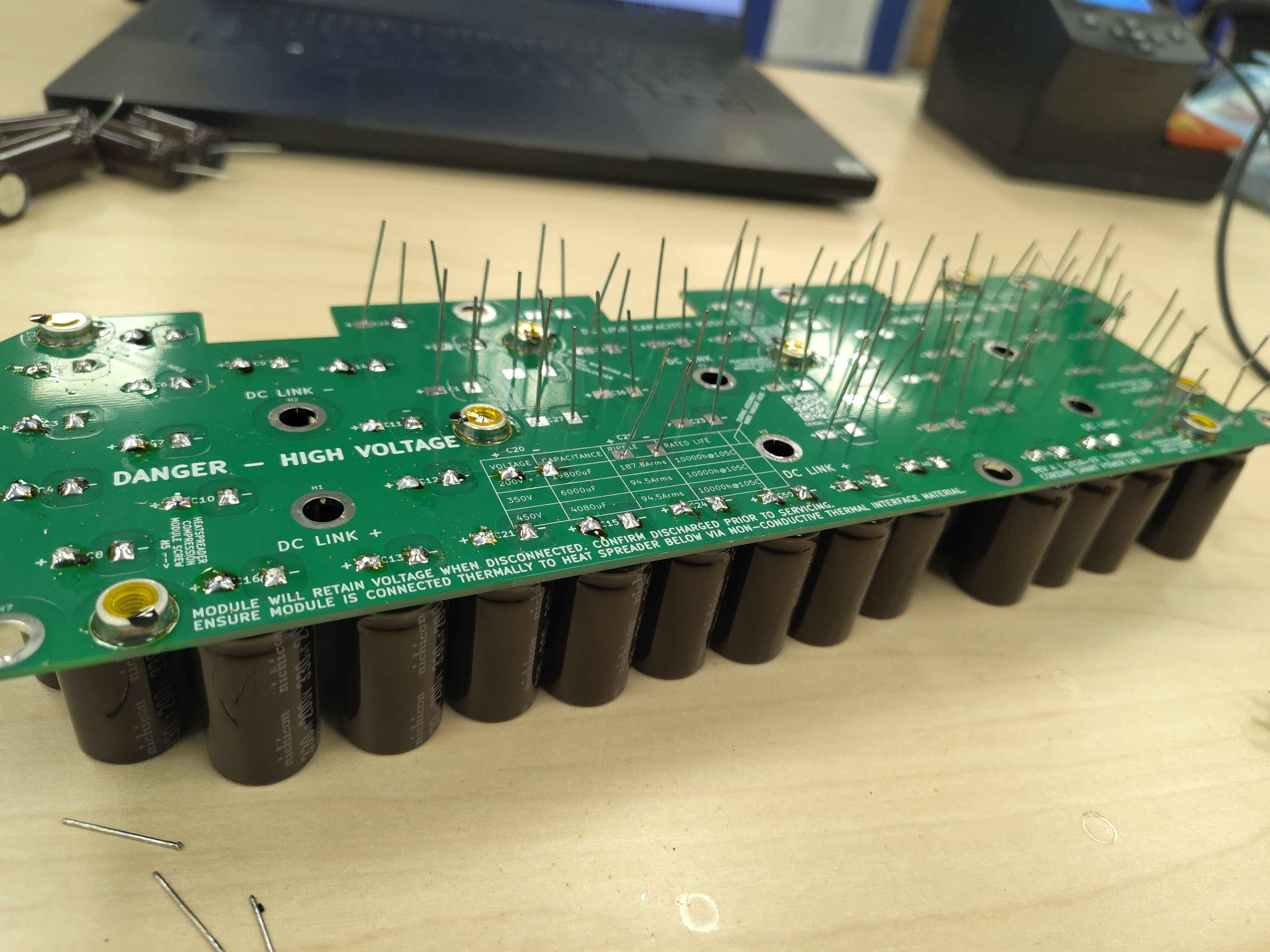 Board with most capacitors soldered and a few leads still waiting to be soldered