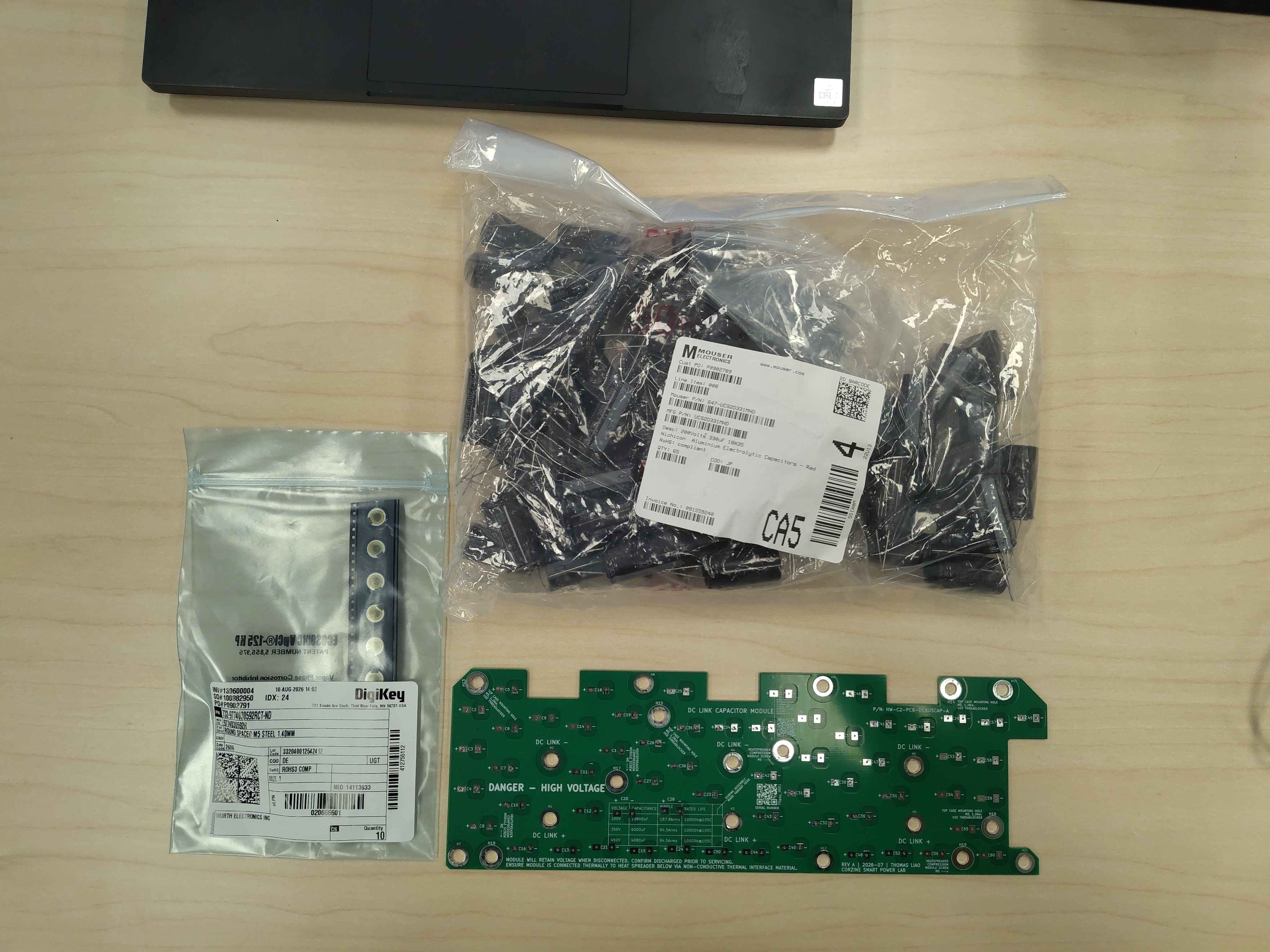 Capacitors, standoffs, and the bare DC-link capacitor PCB laid out for assembly