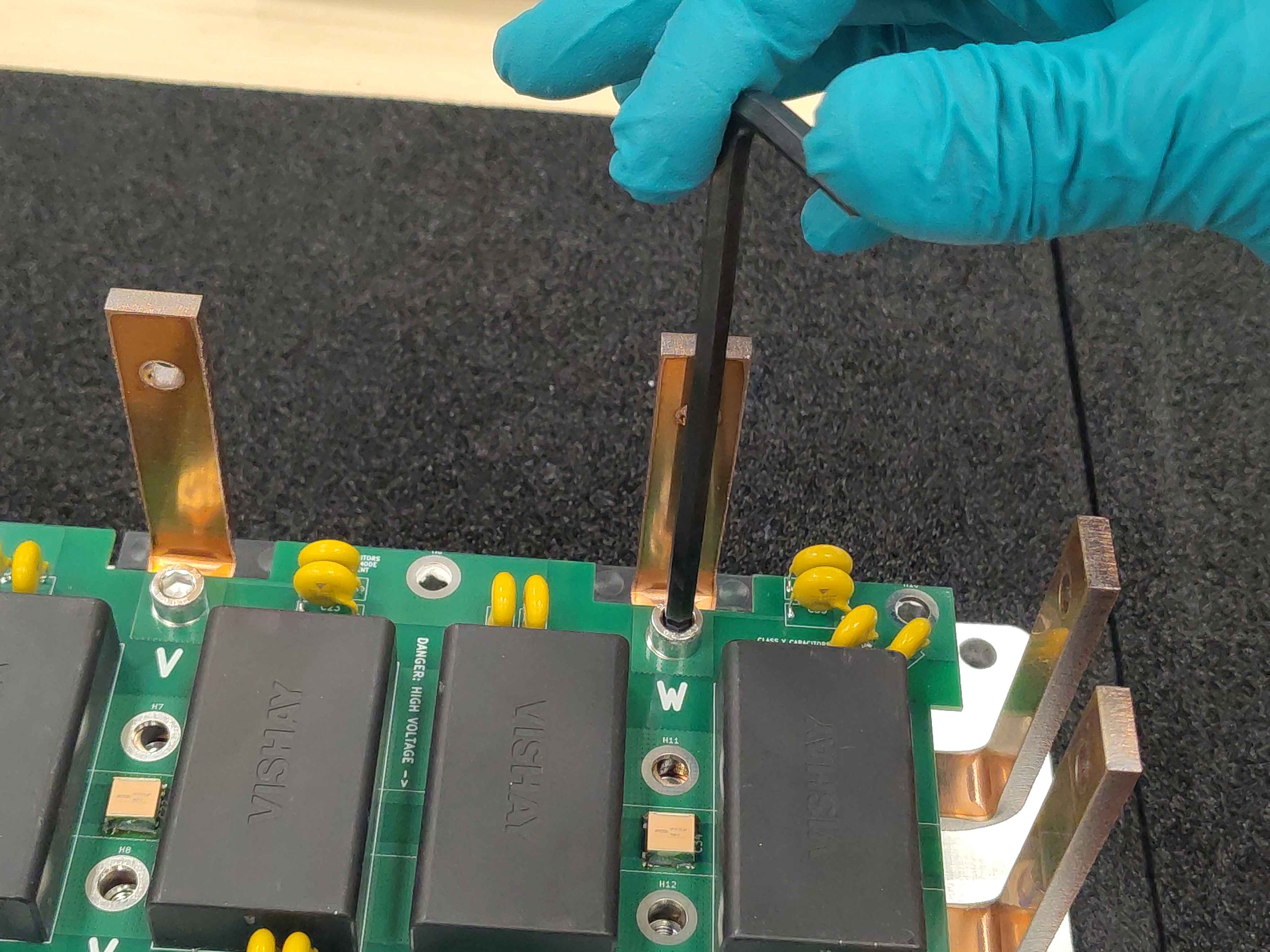 Hand-tightening a phase bus-bar screw for now