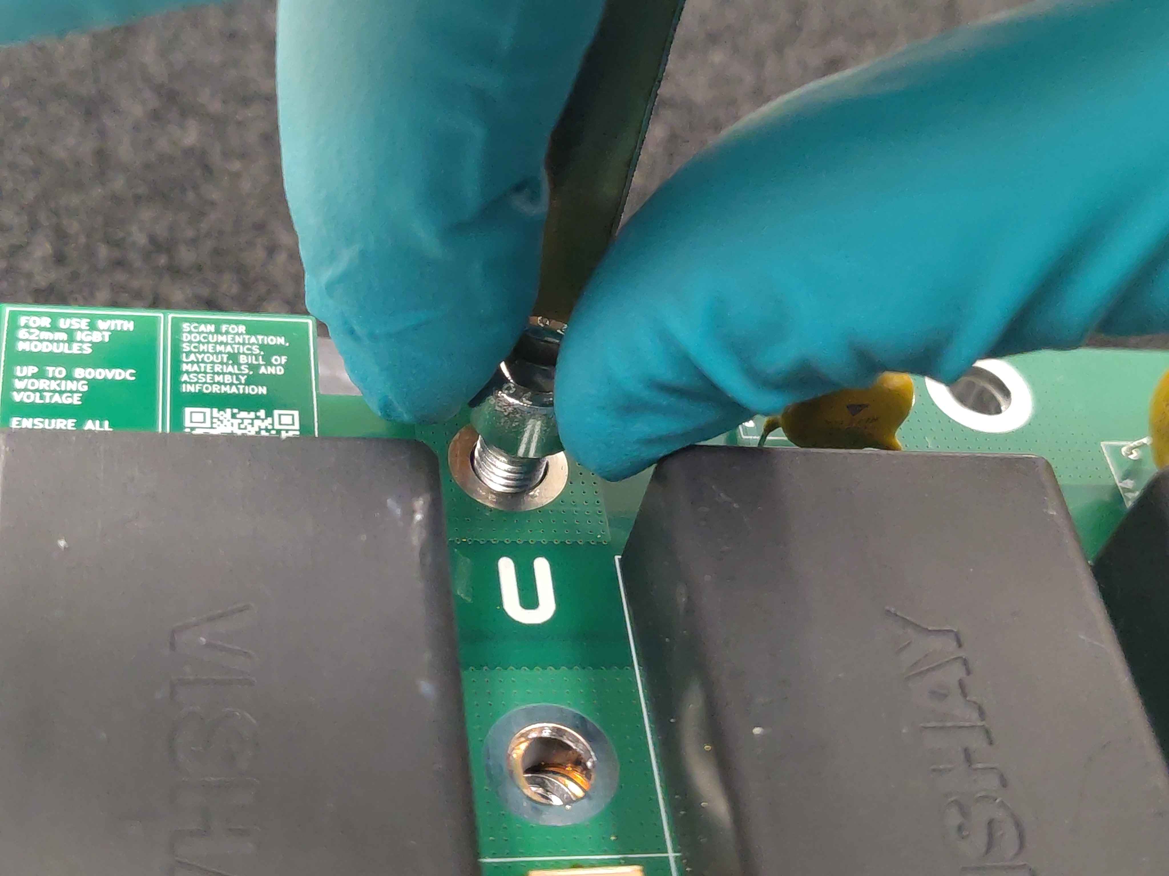 Carefully inserting a phase bus-bar screw
