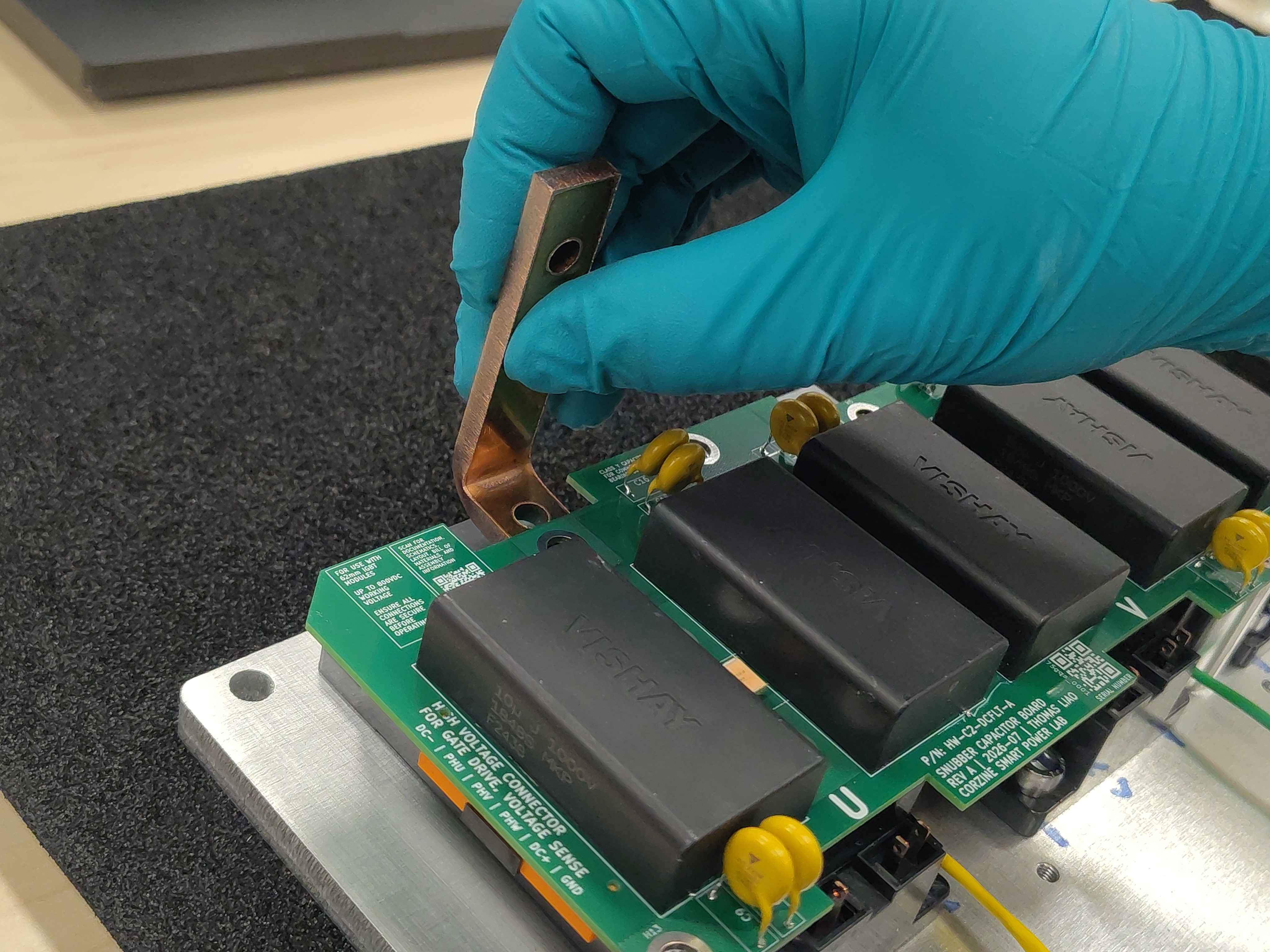 Carefully sliding a phase bus bar into position