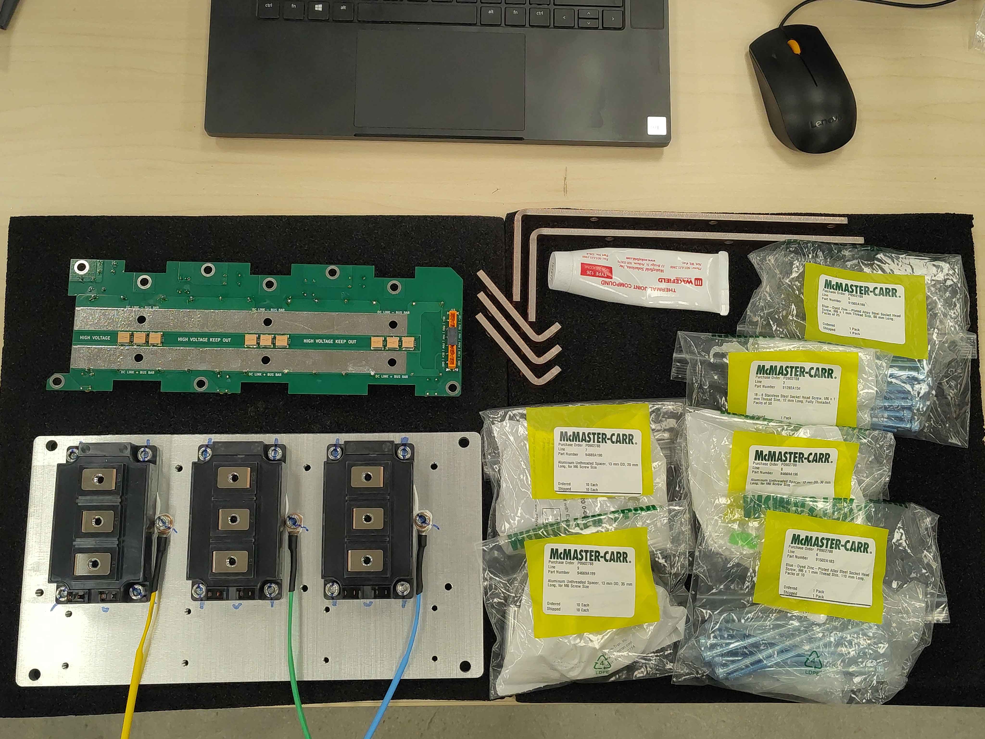 Overview of the workspace with heatspreader, spacers, bus bars, and filter board